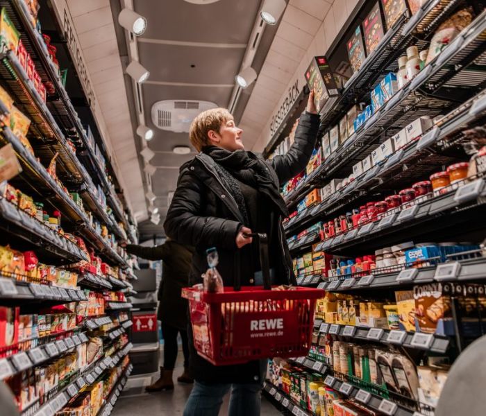 Eine Kundin ist im REWE-Einkaufs-Bus unterwegs, um einzukaufen. (Foto: REWE)